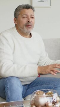 Vertical video: Hearing prompt from right, man leaning in, replying at home with bowl of orbs
