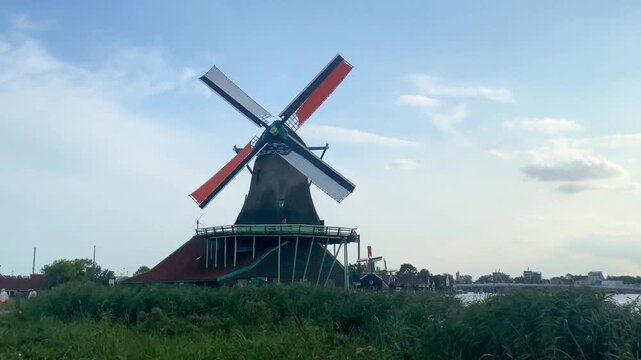 Majestic view of the historic De Kat paint windmill with orange sails rotating at Zaanse Schans Netherlands