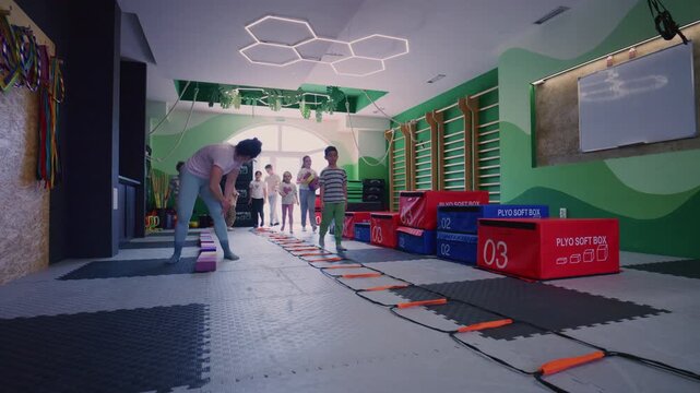 Children participate in fitness exercises, guided by an instructor, to enhance their balance and coordination skills.