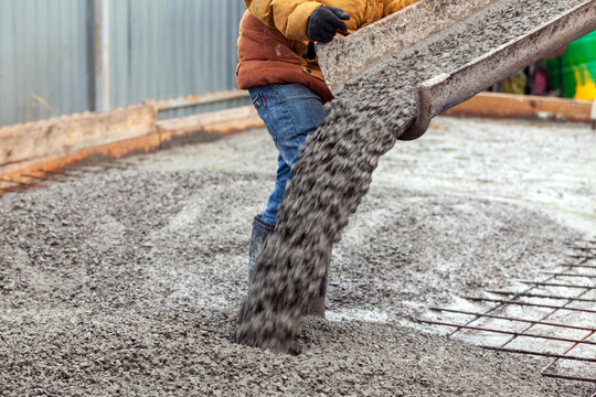 Closeup shot of concrete casting on reinforcing metal bars of floor in industrial construction site