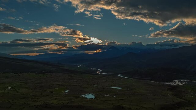 Sunrise breaks through clouds over mountain Time Lapse