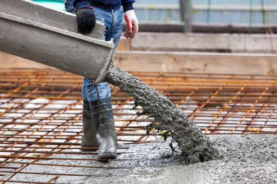 Closeup shot of concrete casting on reinforcing metal bars of floor in industrial construction site