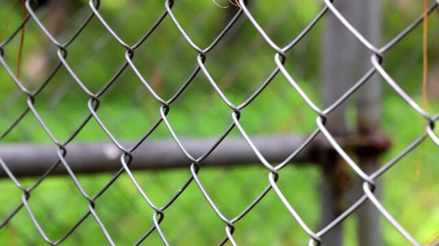 Focus transition across a metal chain link wire fence mesh outdoors 180fps Captured in Cinematic High Detail Footage