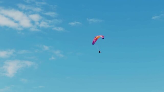 Paraglider Flying In Blue Sky With White Clouds. Extreme Sport. Athlete Gliding In Air