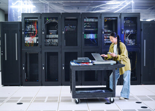 Asian Female Engineer Working in Modern Data Center