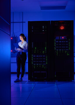Asian Female Cybersecurity Professional Working in Data Center