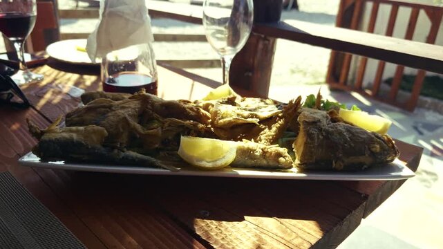 Plate Of Crispy Fried Fish Garnished With Lemon Slices. Seafood Appetizer Platter. Mediterranean Dinner