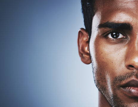 Close-up Half Face Portrait of a Young Man with Intense Gaze and Stubble