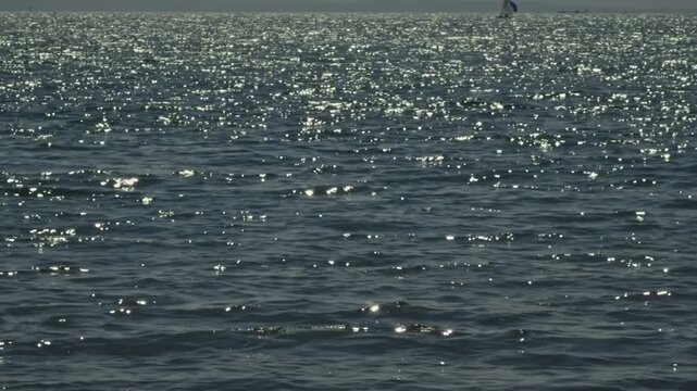 Sparkling Blue Sea Water Surface. With Bright Sun Glare And Ripples On A Sunny Day