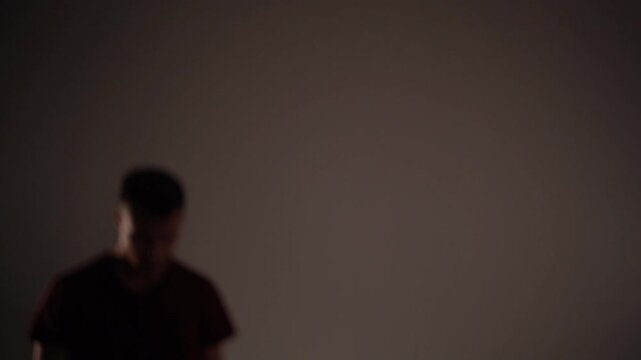 Young man powerfully shoving away from imaginary wall, stumbling backward with explosive movement. 