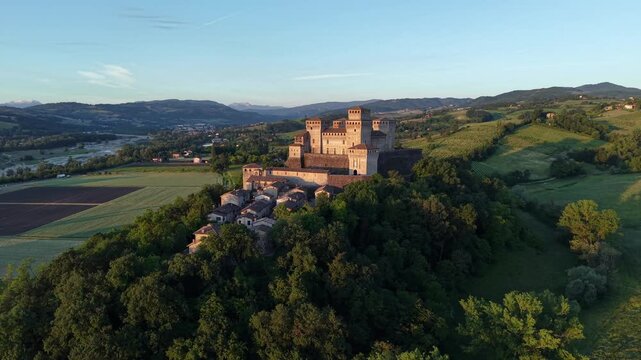 Bird's-eye drone view of Torrechiara Castle, Parma, with panoramic Italian countryside and historic cultural heritage.