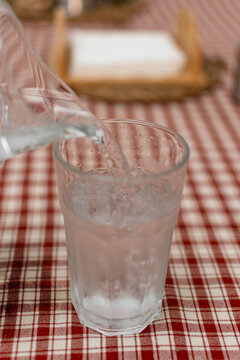 Close up of cold water filling a condensation covered drinking glass