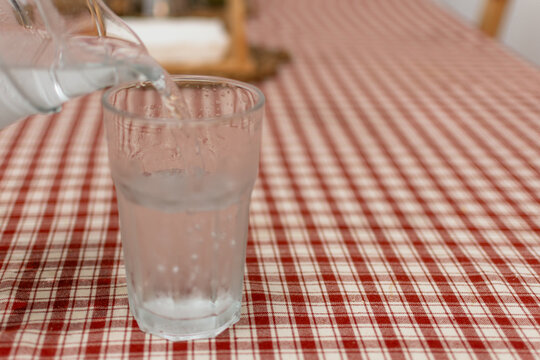 Close up of cold water being poured into a glass with condensation
