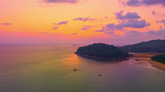 Aerial hyper lapse view of A stunning seascape capturing the vibrant colors of a dramatic sunset sky over a calm beach, Picturesque Tropical Sky at Sunset at Kala island Layan beach Phuket