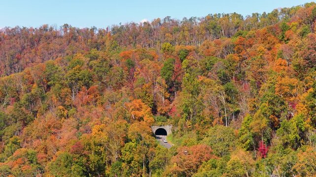 Road trip on Blue Ridge Parkway through Appalachians of North Carolina. Mountain tunnel surrounded by fall seasonal forest and colorful hills.