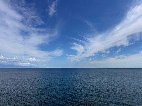 Sea calm blue water and sky clouds horizon 