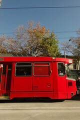 Obraz premium Side Profile of Red Light Rail Vehicle on City Street - Modern Urban Public Transportation and Transit Infrastructure