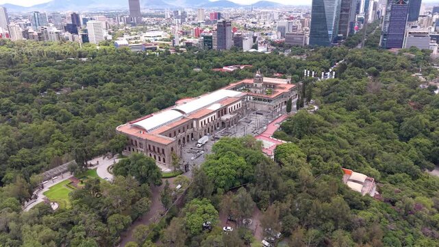 Aerial view of Chapultepec Castle and Mexico City skyline. Drone shot of historic castle, lush green park and skyscrapers on Paseo de la Reforma in CDMX.