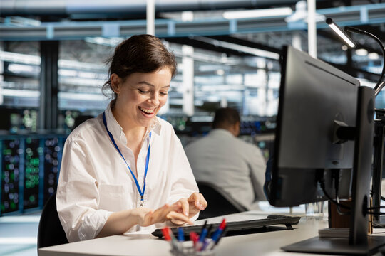 Excited data center engineer celebrates successful AI implementation and improved system results in a server hub.