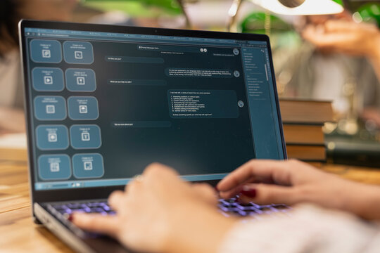 Close up of student using AI virtual assistant on laptop with AI chatbot interface, showing digital learning and study assistant technology for modern education in library environment.