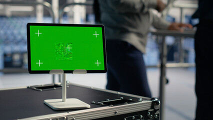 Obraz premium Software developer uses a green screen tablet to manage AI systems, machine learning workflows and server performance.