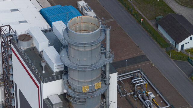 Aerial view of the Trianel Gaskraftwerk Hamm gas power plant with its large industrial exhaust stack, complex piping, and surrounding infrastructure in Hamm, Nordrhein-Westfalen, Germany.
