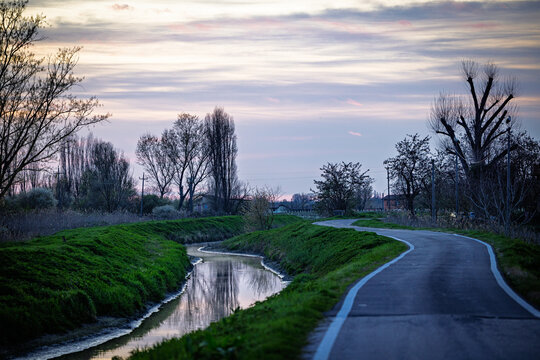 Winding country road and canal at sunset in Emilia-Romagna