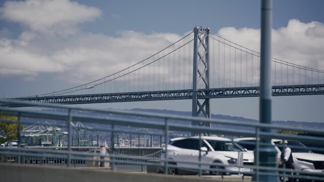 View Of Suspension Bridge Tower Near Car Parking Lot In San Francisco