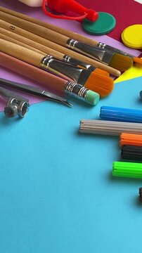 School supplies panning video footage paintbrushes markers compass and watercolor discs on colorful paper sheets back to school concept