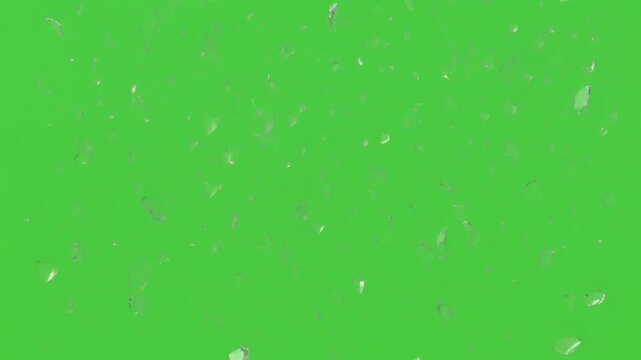 Falling shards of broken glass isolated on chroma key green background flying