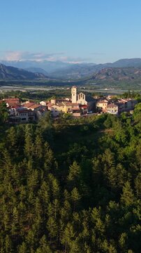 Aerial view of the hilltop village of Ventavon with French Alps mountain range in background. Durance Valley, Hautes-Alpes, France