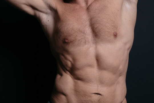 an athletic-built mature man with a defined abdominal area and large muscles after a grueling workout and a visit to the tanning salon. body parts: firm breasts and elastic muscles. bodybuilding poses