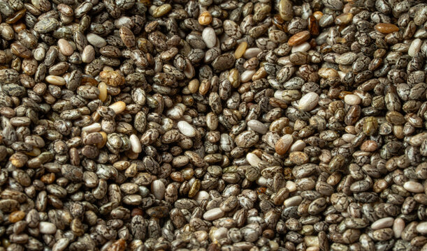 Chia seeds fullframe macro closeup showing detailed texture and natural grain pattern healthy superfood and nutrition concept. 