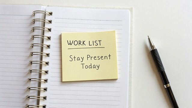 Inspirational Note on Sticky Pad in Notebook Showcasing Work List and Importance of Staying Present in Daily Tasks