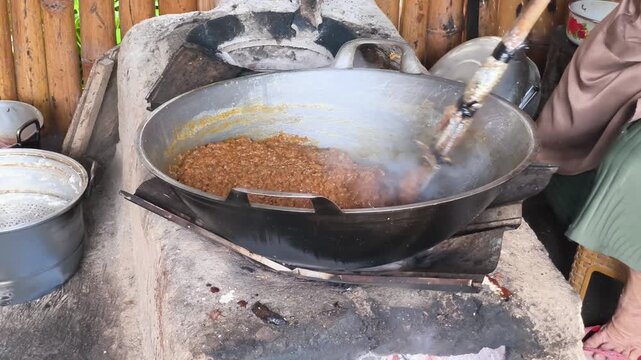 Close up shot of making traditional Javanese dodol jenang over a rustic traditional stove