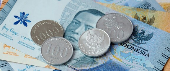 Indonesian rupiah money bills and coins on table. Indonesia cash of IDR currency © Larysa