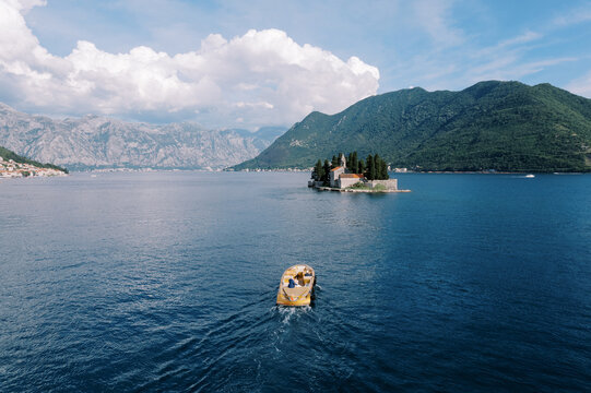 Boat approaching island monastery in Kotor Bay Montenegro