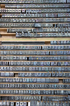 Collection of traditional letterpress printing equipment, metal type, wooden letters and vintage typography tools used in historical printing and typesetting.