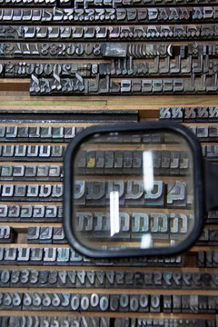 Collection of traditional letterpress printing equipment, metal type, wooden letters and vintage typography tools used in historical printing and typesetting.