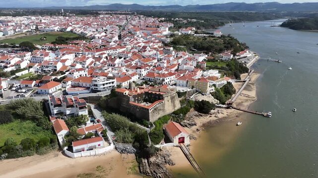 Aerial pan right tracking shot of the charming fortification Forte de S&atilde;o Clemente in Vila Nova de Milfontes, Portugal, nestled by the Mira River estuary.