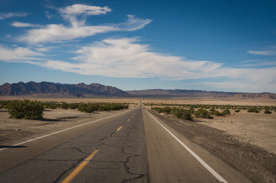 A long straight highway running through the desert near the Nevada California border.