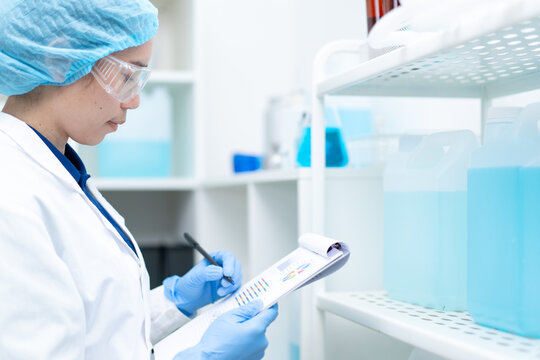 scientist checking stock inventory liquid chemical water recheck experiment in laboratory, technician with blue glove research analyze biochemistry for healthcare medical innovation