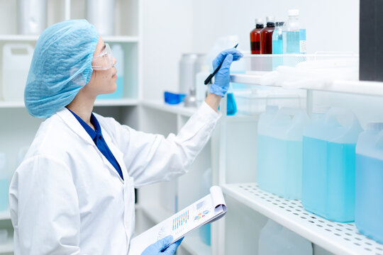 scientist checking stock inventory liquid chemical water recheck experiment in laboratory, technician with blue glove research analyze biochemistry for healthcare medical innovation