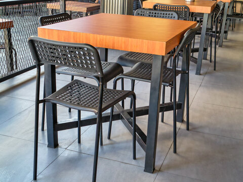 Square tables and metal chairs in the dining area of ​​a contemporary cafe.