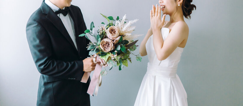 The groom presents the bride with a bouquet of flowers, and she is surprised and astonished (surprise).