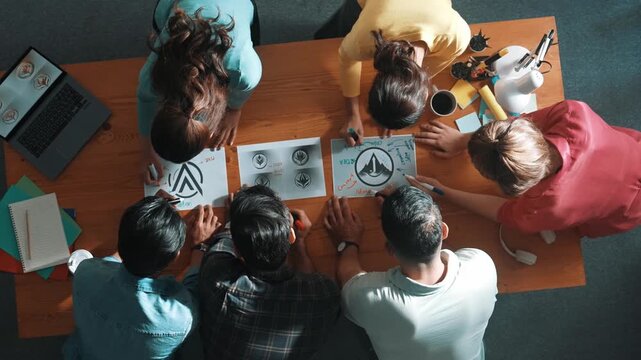 Top view of smart business team put graphic logo on meeting table and start to design while explain idea. Aerial view of project manager show and present plan while talk about concept art. Symposium.
