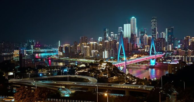 Illuminated city skyline and bridge over the river at night, Chongqing, China
