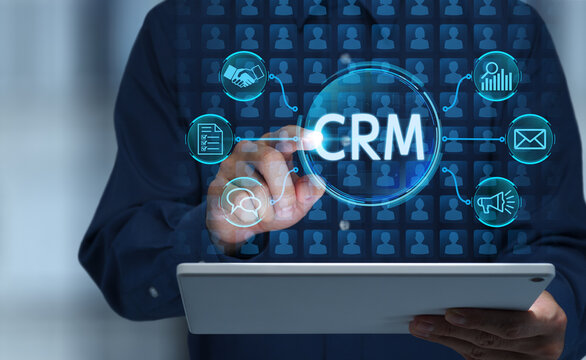 Customer relationship management CRM solution integrating customer data and information. Analyzing communication history and marketing campaigns. Businessman tapping CRM icon on digital tablet.