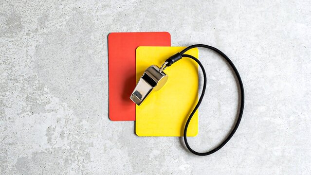 Red and yellow referee cards with whistle for football match officiating