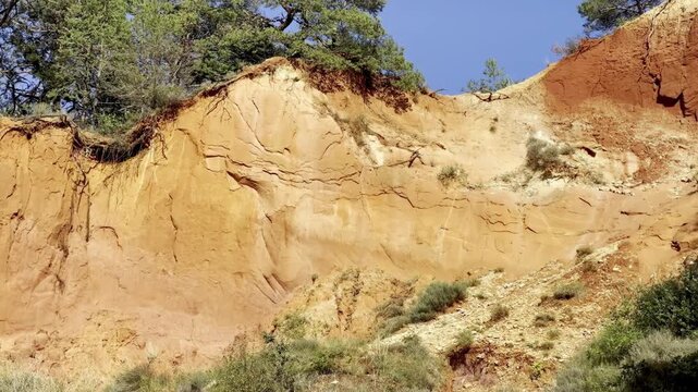 Close view of vividly colored eroded ochre cliff walls in golden